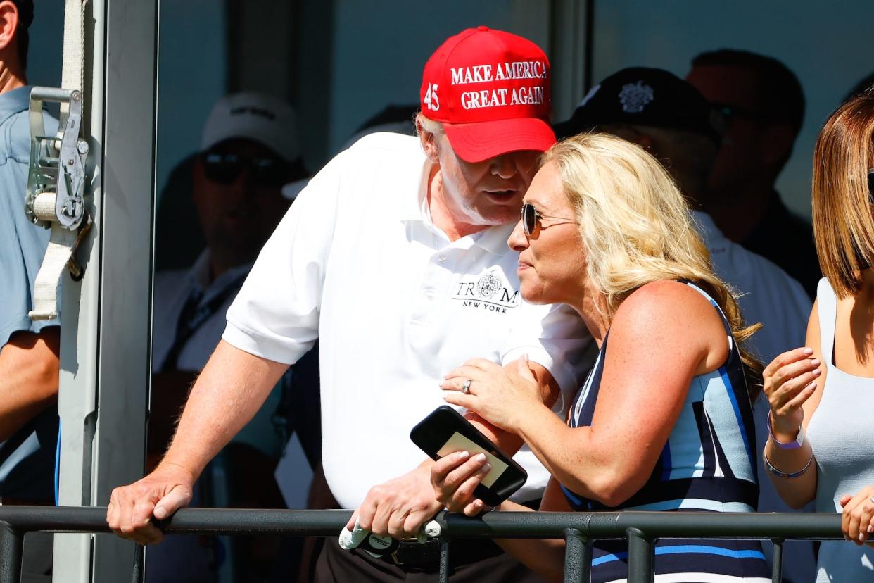 Former US President Donald Trump chats with Republican Rep Marjorie Taylor Greene of Georgia at the 16th tee during the second round of the LIV golf invitational series on July 30, 2022 in Bedminster, New Jersey.