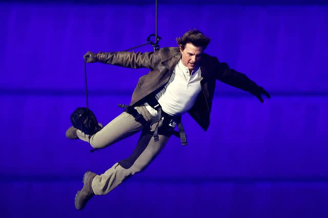 <p>Fabrizio Bensch- Pool/Getty</p> Tom Cruise jumps from the Stade de France during the 2024 Olympics closing ceremony in Paris