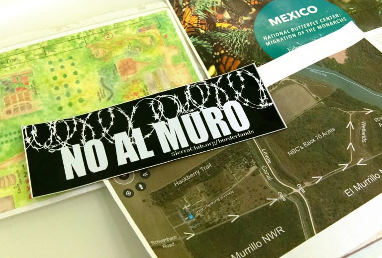 A sticker saying "No to the wall" in Spanish is seen near a map of the National Butterfly Center, which is actively campaigning against the project