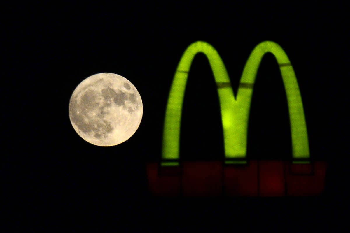 A Sturgeon supermoon rises beside a McDonald’s logo as seen from Jalandhar on August 1, 2023 (AFP via Getty Images)