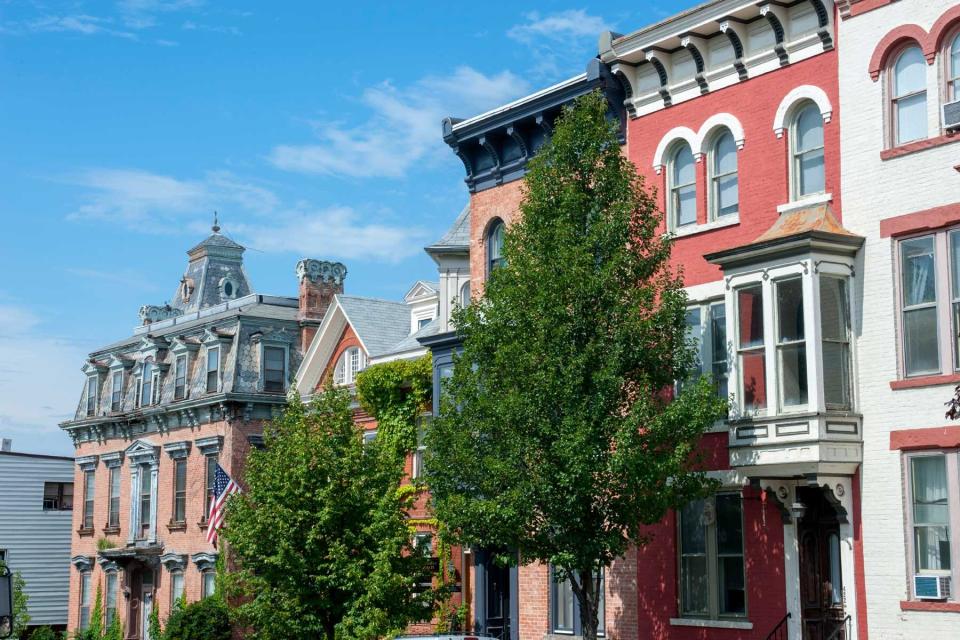 Brick houses and an American flag on Warren Street in the town of Hudson on Hudson River in New York State