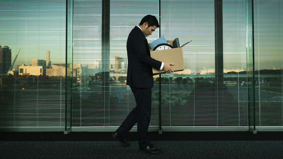 Subject: A Japanese business office worker leaving his job with all his belonging in a layoff and economic recession.