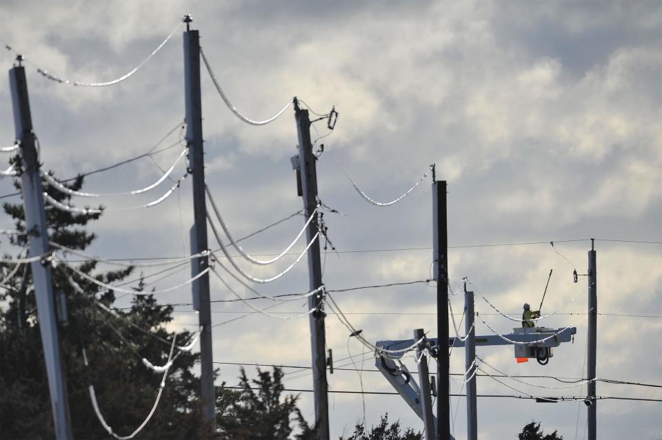 Snow-coated utility lines sag on Wednesday along Salt Marsh Road in East Sandwich as a electric line crew works to restore power to the beachfront area.