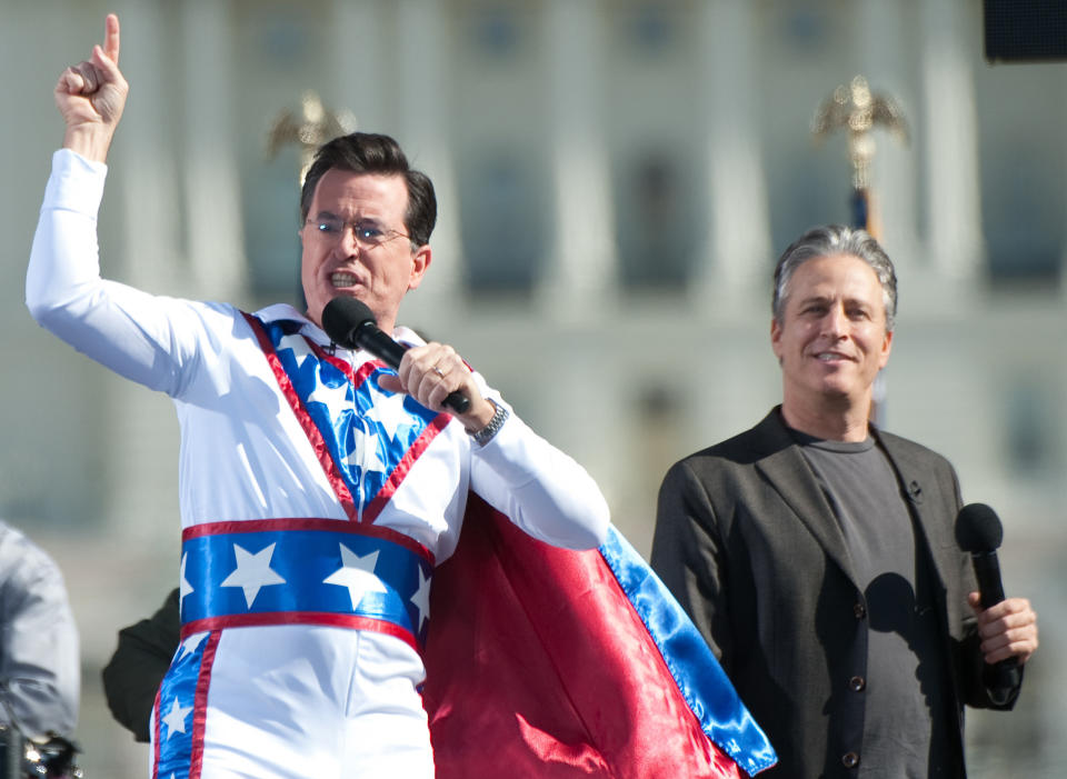 Comedy Central comedians and television hosts Jon Stewart (R) and Stephen Colbert (L) speak as thousands gather for the 'Rally to Restore Sanity And/Or Fear' on the National Mall in Washington, DC, on October 30, 2010. AFP PHOTO / Saul LOEB (Photo credit should read SAUL LOEB/AFP/Getty Images)