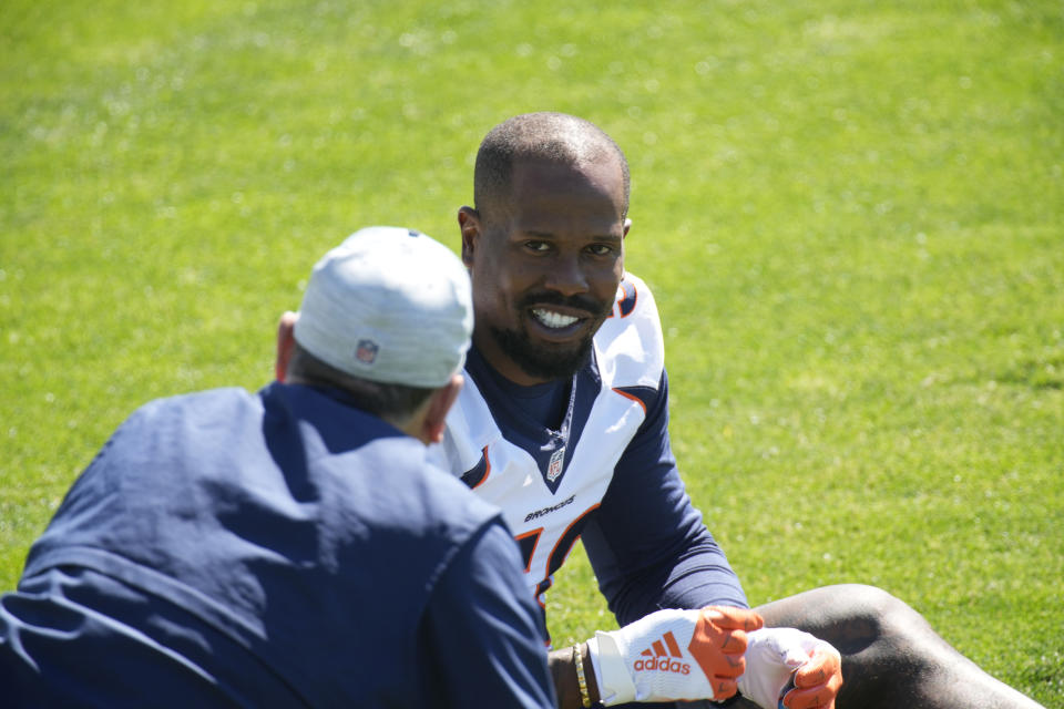 FILE - Denver Broncos outside linebacker Von Miller speaks to an unidentified person during an NFL organized training session at the team's headquarters in Englewood, Colo., in this Tuesday, June 1, 2021, file photo. From players getting COVID-19 vaccinations to relaxed coronavirus protocols to lineup issues, the NFL faces a multitude of questions as training camps open. (AP Photo/David Zalubowski, File)