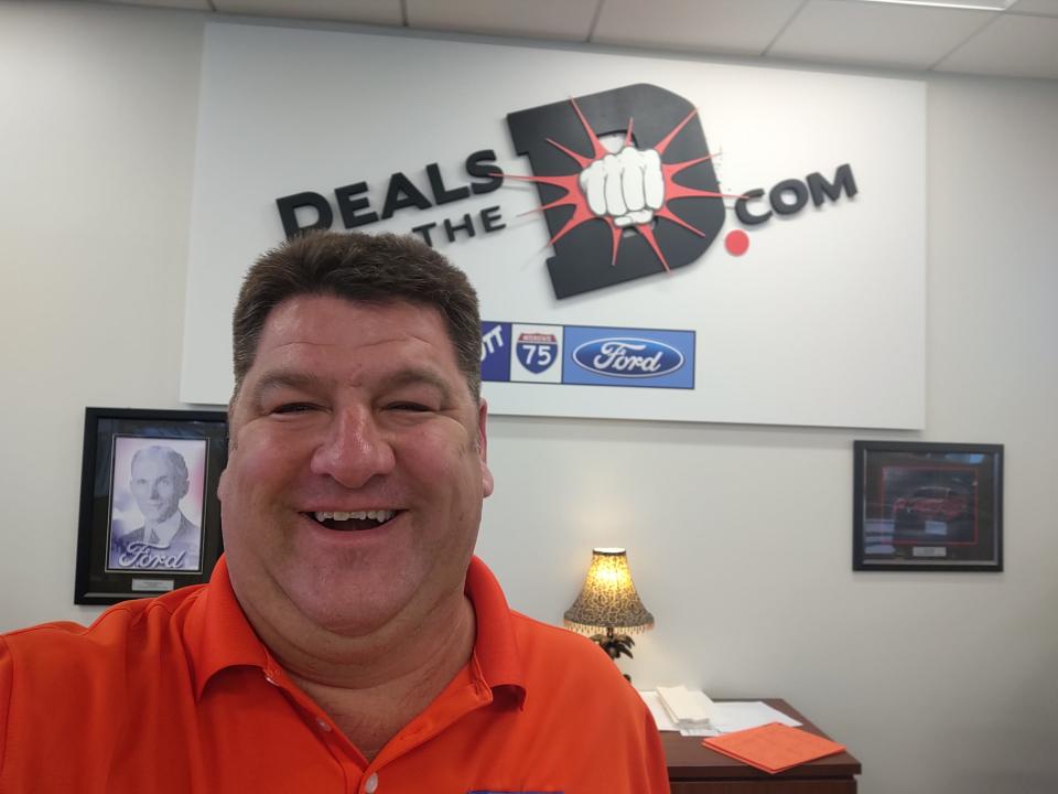 RJ Magiera, a salesman at Szott Ford in Holly who is seen here Nov. 15, 2021 beside a photo of founder Henry Ford, said the Ford Bronco Sport has design elements meant for campers and fishermen.