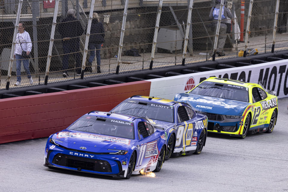 Denny Hamlin (11) leads Chase Elliott (9) and Ryan Blaney (12) during a NASCAR Cup Series auto race, Sunday, March 17, 2024, in Bristol, Tenn. (AP Photo/Wade Payne)