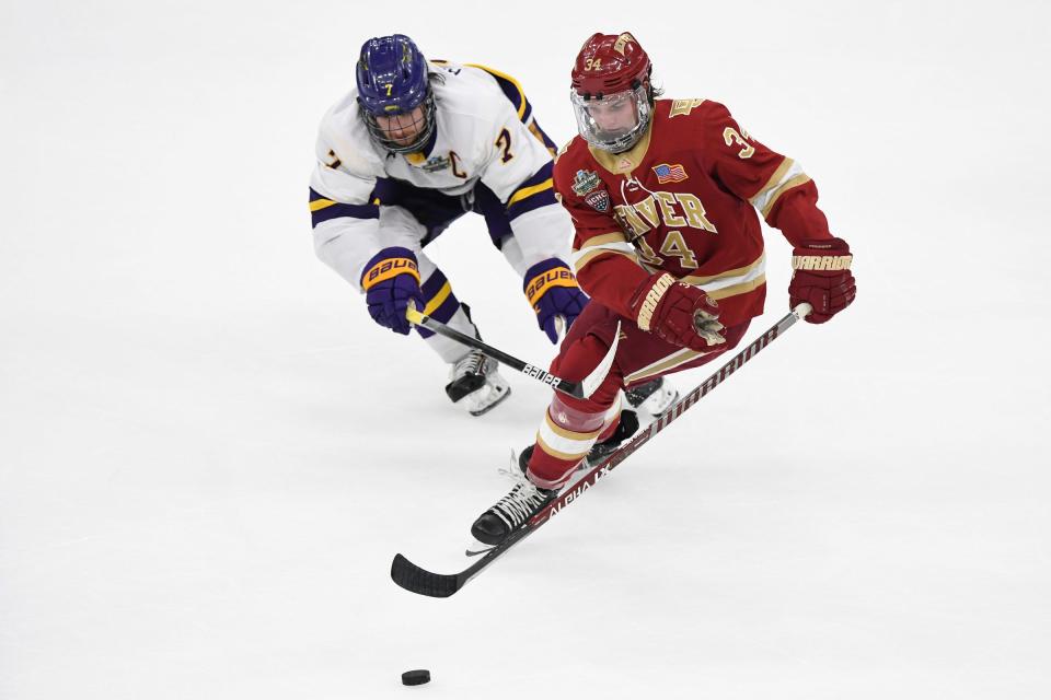 Denver Pioneers forward Carter Mazur (34) controls the puck in front of Minnesota State Mavericks defenseman Wyatt Aamodt (7) during the third period of the 2022 Frozen Four national championship game at TD Garden in Boston on Saturday, April 9, 2022.