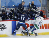 Winnipeg Jets' Adam Lowry (17) checks Vancouver Canucks' Brad Hunt (77) during second-period NHL hockey game action in Winnipeg, Manitoba, Thursday, Jan. 27, 2022. (John Woods/The Canadian Press via AP)