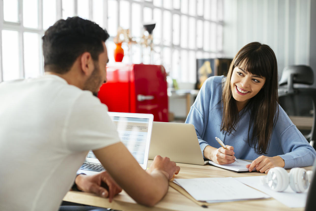 Smiling colleagues working at desk in office