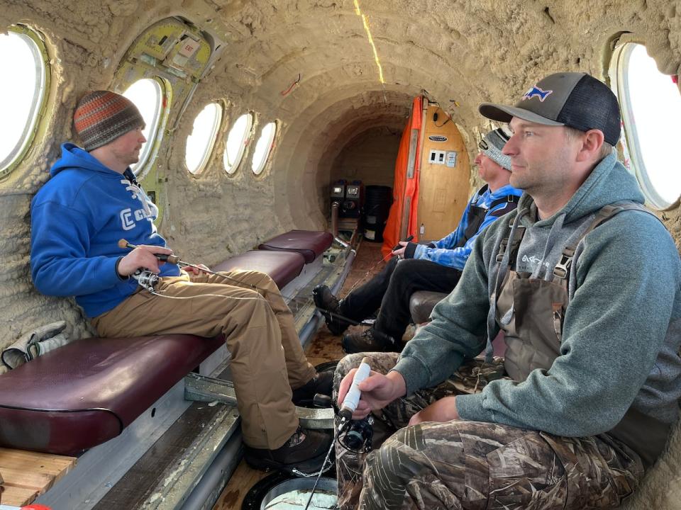From left to right, Davis, Seretsky and Janzen fish inside the aircraft. The portable heater at the back and its duct system keep the inside temperature around 20 C.