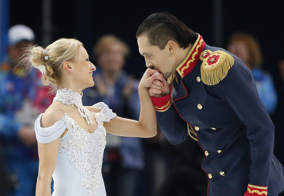 Maxim Trankov kisses the hand ofTatiana Volosozhar of Russia at the end of their performance during the Team Pairs Short Program at the Sochi 2014 Winter Olympics, February 6, 2014. REUTERS/Lucy Nicholson