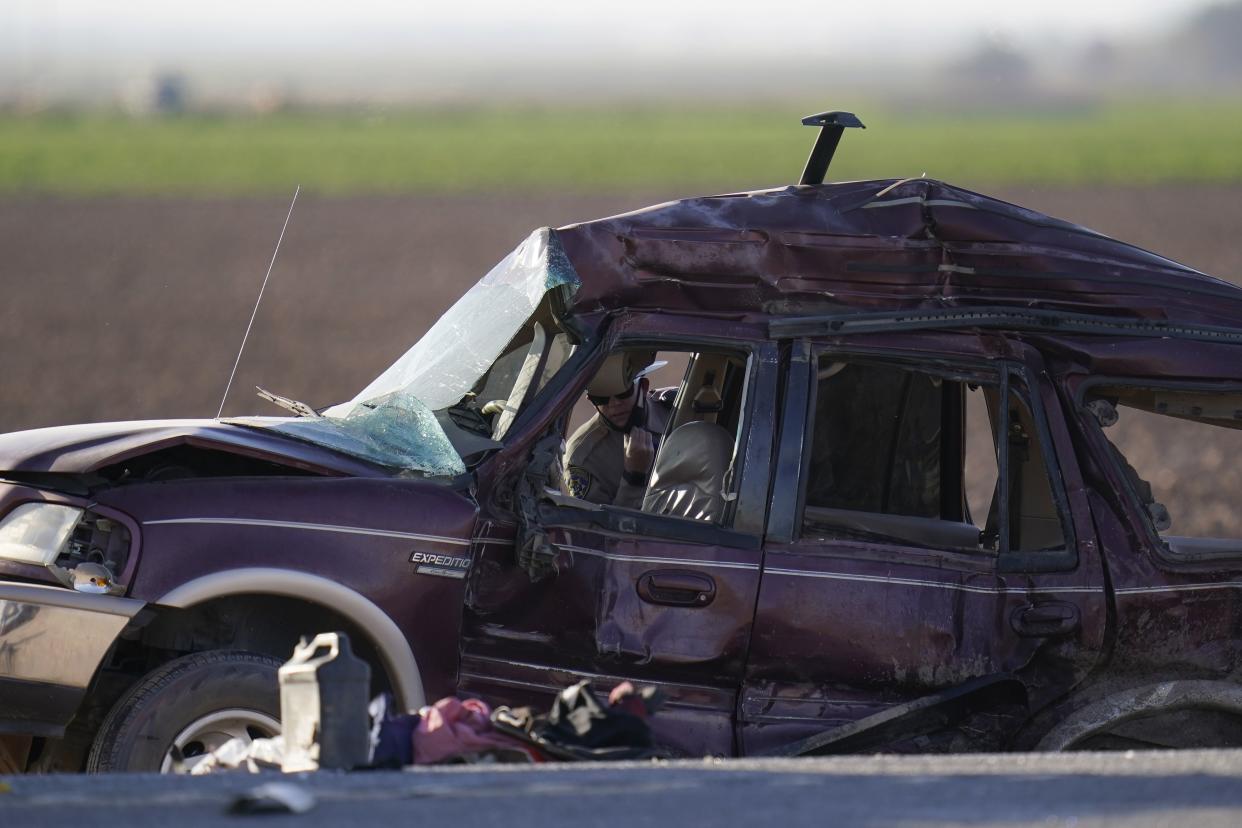 Law enforcement officers sort evidence and debris at the scene of a deadly crash in Holtville, Calif. on Tuesday, March 2, 2021. Authorities say a semi-truck crashed into an SUV carrying 25 people on a Southern California highway, killing at least 13 people.