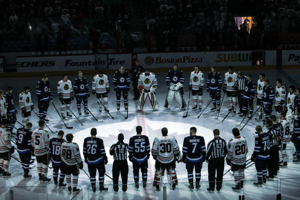 The Winnipeg Jets and Chicago Blackhawks, wearing jerseys reading "Broncos" on their backs,&nbsp;observe a minute of silence for the Humbolt Broncos on Saturday. (Photo: USA Today Sports / Reuters)