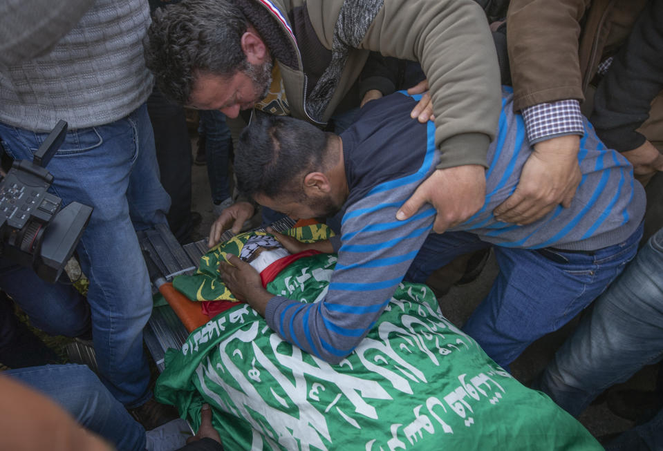 Palestinians mourn by the body of Atef Hanaisheh, 45 during his funeral procession in the West Bank village of Beit Dajan, east of Nablus, Friday, March 19, 2021. The Palestinian Health Ministry said Israeli troops shot and killed a Palestinian protester during clashes in the occupied West Bank. (AP Photo/Nasser Nasser)