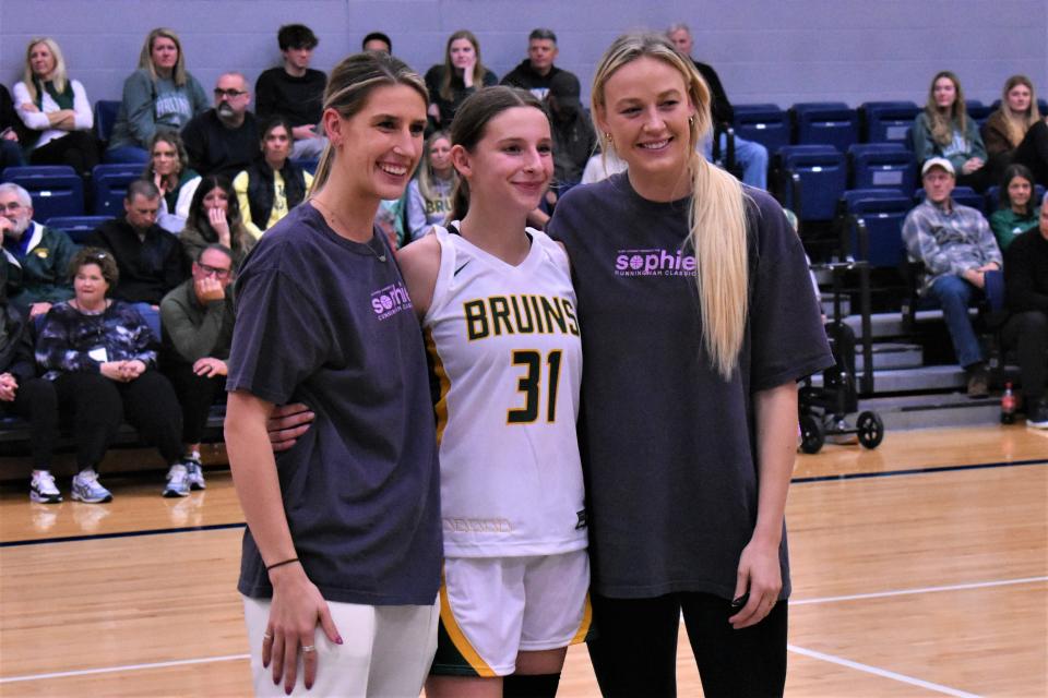 Lindsey Cunningham (left) and Sophie Cunningham (right) pose with Mari Miller (center) after Miller won the Rock Bridge most valuable player award after a game against Blue Valley North on December 2, 2022, at the Columbia College’s Southwell Complex in Columbia, Mo.