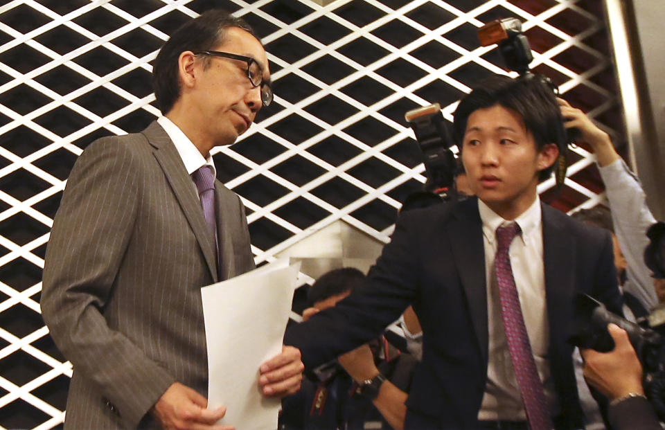 Takashi Niigaki, left, ghost writer of well known deaf composer Mamoru Samuragochi, a composer Japanese have likened to Beethoven for supposedly composing music despite a severe hearing impairment, is escorted to leave a press conference in Tokyo, Thursday, Feb. 6, 2014. Niigaki said he hopes to continue composing and performing, despite the uproar over Samuragochi’s admission on Wednesday that he did not write the pieces he is best known for, such as his “Hiroshima Symphony.” (AP Photo/Eugene Hoshiko)