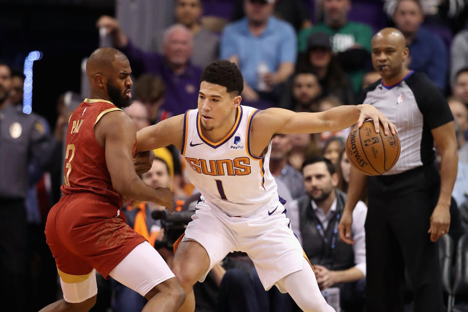 PHOENIX, ARIZONA - FEBRUARY 04:  Devin Booker #1 of the Phoenix Suns handles the ball against Chris Paul #3 of the Houston Rockets during the first half of the NBA game at Talking Stick Resort Arena on February 04, 2019 in Phoenix, Arizona. (Photo by Christian Petersen/Getty Images)