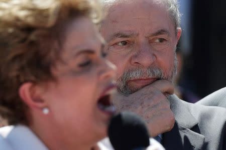 Brazil's former President Luiz Inacio Lula da Silva (R) listens as suspended President Dilma Rousseff addresses supporters, after the Brazilian Senate voted to impeach her for breaking budget laws, at Planalto Palace in Brasilia, Brazil, May 12, 2016. REUTERS/Ueslei Marcelino