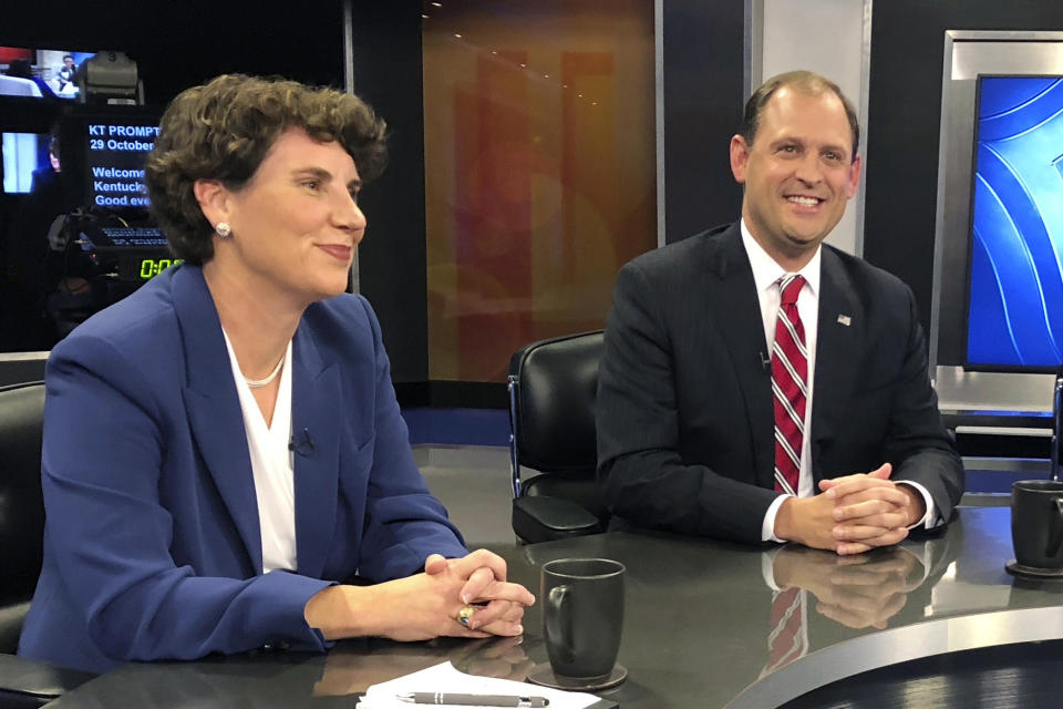 In this Oct. 29, 2018 photo, Kentucky’s 6th Congressional District candidates Amy McGrath, left, Andy Barr, center, pose for photos before the start of a debate in Lexington, Ky. Barr, the Republican incumbent, faces a tough challenge from McGrath, a Democrat. The Lexington-area battle pits third-term Republican Rep. Andy Barr against Democrat Amy McGrath, a retired Marine fighter pilot. Trump won the 6th District by more than 15 percentage points in 2016. But with the help of carefully-shaped campaign ads that went viral, McGrath holds the edge on campaign fundraising. (AP Photo/Adam Beam)
