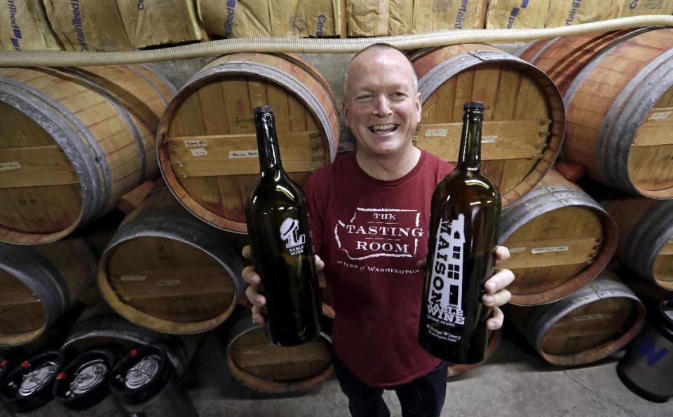 In this photo taken Tuesday, Jan. 10, 2017, winemaker Paul Beveridge displays the type of wine "growler" bottle he would like to see available to consumers, at his winery in Seattle. Wine drinkers are one step closer to being able to purchase and refill their favorite pours in reusable growlers closer to home instead of making a trip to the winery. Some state winemakers are pushing House Bill 1039 as a way to expand wine sales and reduce the carbon footprint of wine bottles. If approved, consumers would be able to bring or buy refillable growlers at any business that has the license to sell wine. (AP Photo/Elaine Thompson)