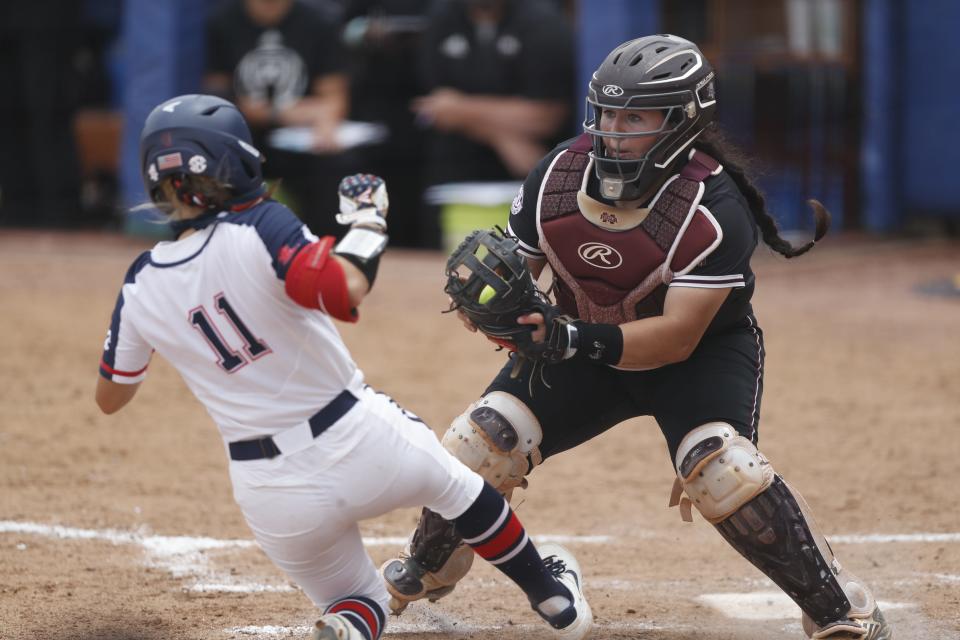 Ole Miss softball center fielder Tate Whitley (No. 11) tries to slide under the catch of Mississippi State catcher Mia Davidson at the SEC Tournament in Tuscaloosa, Alabama, on May 12, 2021.