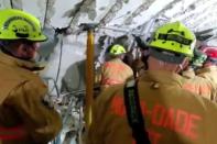 This handout video grab taken from a video posted by the Miami-Dade Fire Rescue shows firefighters working in the basement parking garage (City of Miami Fire-Rescue/AFP vi)