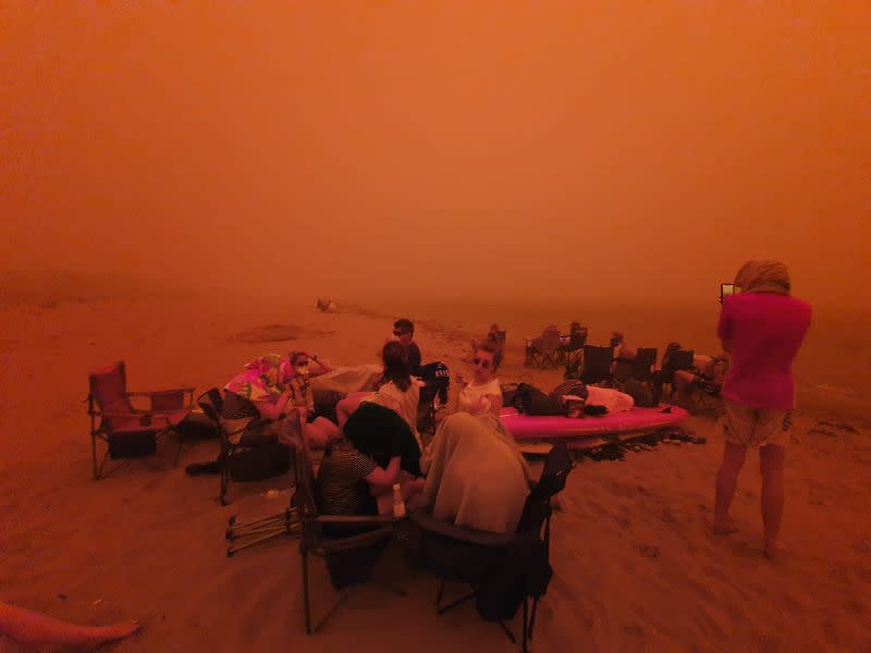 This photo shared online shows people evacuating to a beach in Batemans Bay. Source: Twitter/Alastair Prior