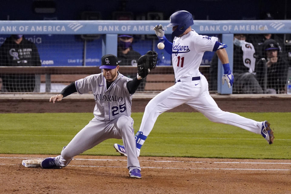 Los Angeles Dodgers' Justin Turner, right, is safe at first as Colorado Rockies first baseman C.J. Cron is unable to field the throw during the third inning of a baseball game Tuesday, April 13, 2021, in Los Angeles. (AP Photo/Mark J. Terrill)