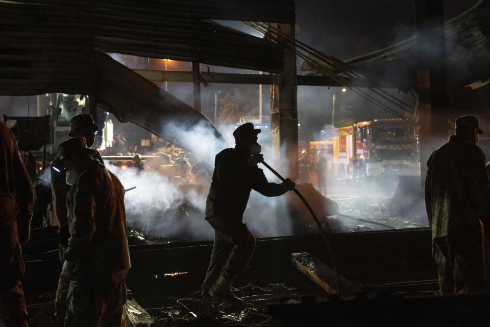Volunteers and firefighters worked through the night to extinguish the flames in Kremenchuk.  (Efrem Lukatsky / AP)