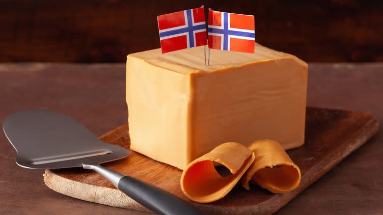 Norwegian brunost cheese on cutting board with slicer