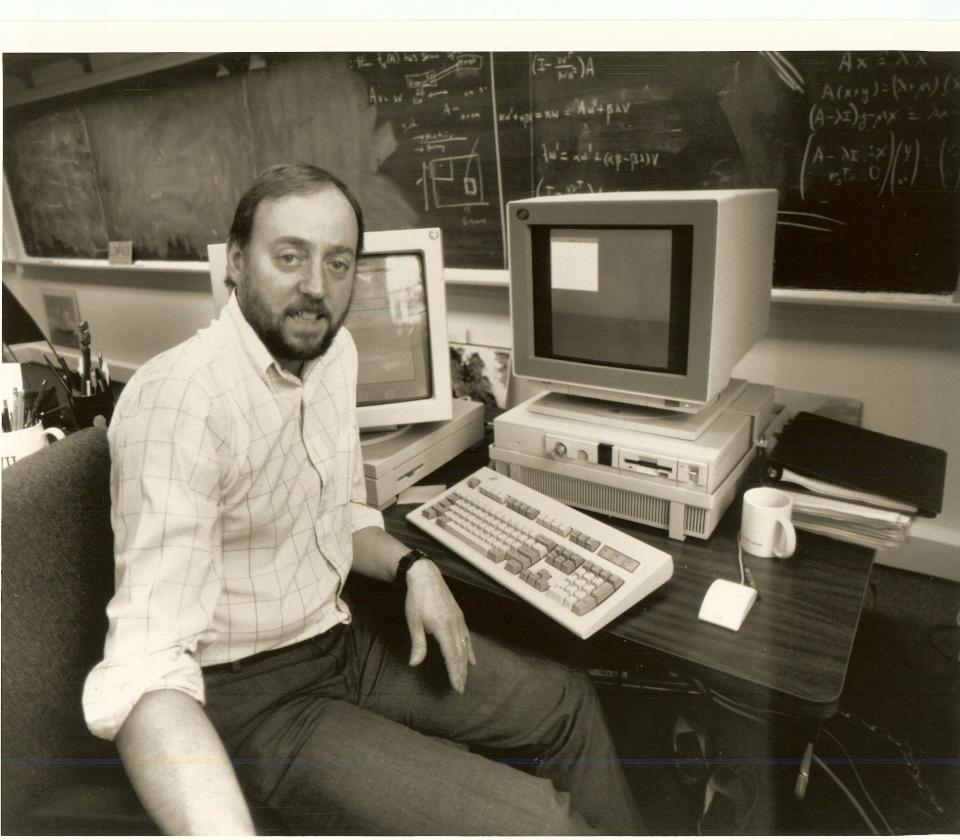 Jack Dongarra in 1990 at the University of Tennessee poses with an IBDM PC and a Sun Microsystems workstation.