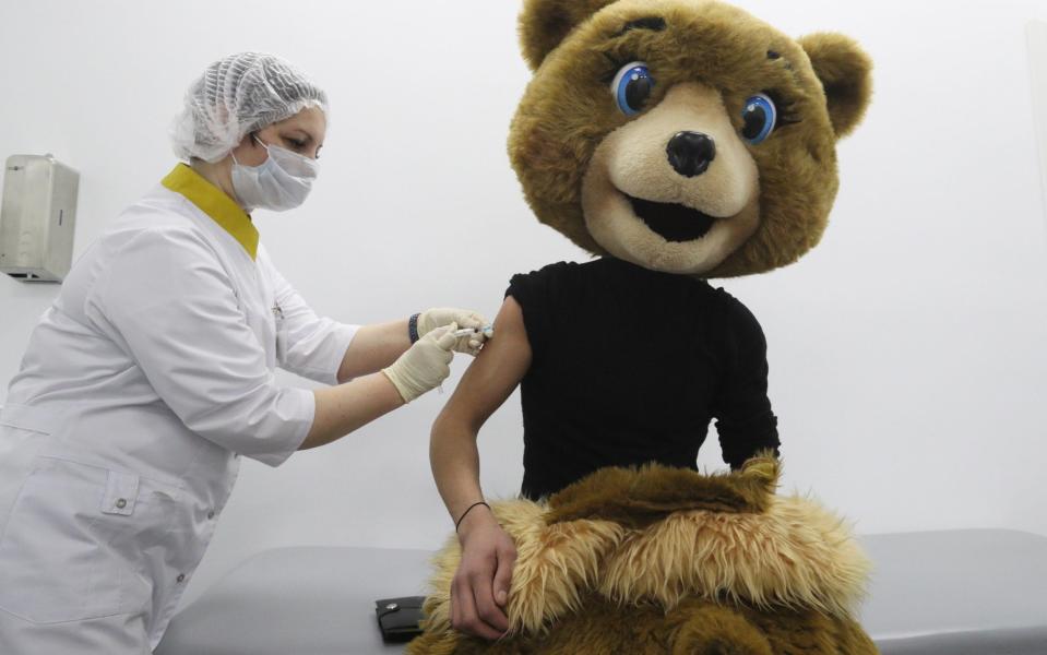 A nurse injects a performer in a bear costume with the Gam-COVID-Vac vaccine (under the brand name of Sputnik V) at a temporary COVID-19 vaccination site in a Moscow shopping centre  - Getty