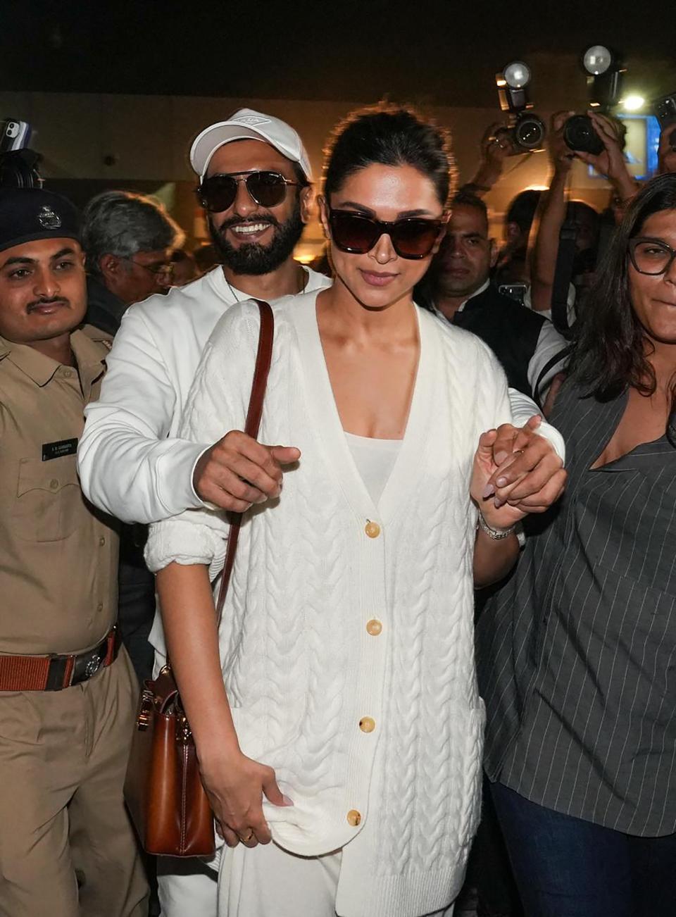 This handout photograph taken and released by Reliance on February 29, 2024, shows bollywood actors Ranveer Singh (3L) and Deepika Padukone (3R) upon their arrival at Jamnagar Airport in Jamnagar, to attend a three-day pre-wedding celebration hosted by billionaire tycoon Mukesh Ambani, for his son Anant Ambani and Radhika Merchant.