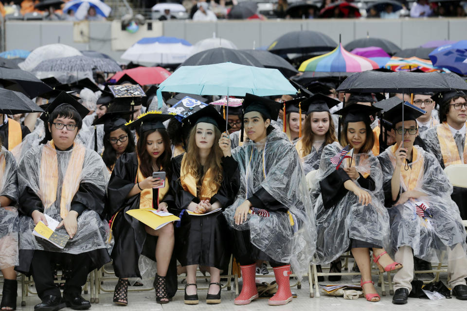 New graduates hold umbrellas to keep dry during the Bergen Community College commencement at MetLife Stadium in East Rutherford, N.J., Thursday, May 17, 2018. (AP Photo/Seth Wenig)