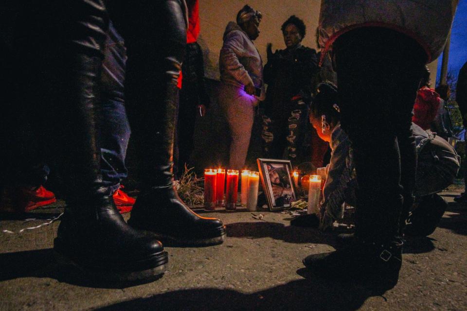 Mourners stand around a vigil for Quillan Jacobs on Friday evening in the alley next to the Second Baptist Church in downtown Columbia.