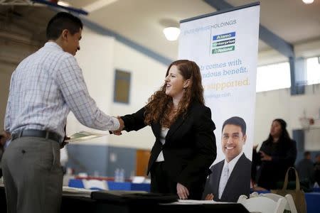 Jessica Kolber (R) shakes hands with a job seeker at a job fair in Burbank, Los Angeles, California March 19, 2015. REUTERS/Lucy Nicholson