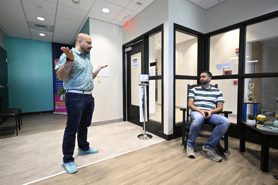 Andres Acosta Ardila, left, director of community relations at Pineapple Healthcare, greets Fernando Hermida as he waits for his appointment at the medical clinic in Orlando, Fla., on May 28, 2024. (AP Photo/Phelan M. Ebenhack)