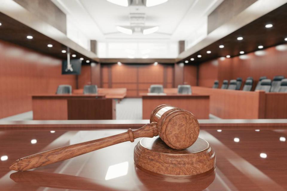 Interior of an empty courtroom with gavel and sounding block on the desk.