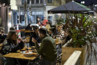 Members of the public are seen at a bar in Manchester's Northern Quarter after Prime Minister Boris Johnson set out new restrictions to last "perhaps six months" to slow the renewed spread of coronavirus, Manchester, England, Tuesday Sept 22, 2020. The UK has reached "a perilous turning point", Boris Johnson said as he set out a raft of new coronavirus restrictions for England. ( AP Photo/Jon Super)