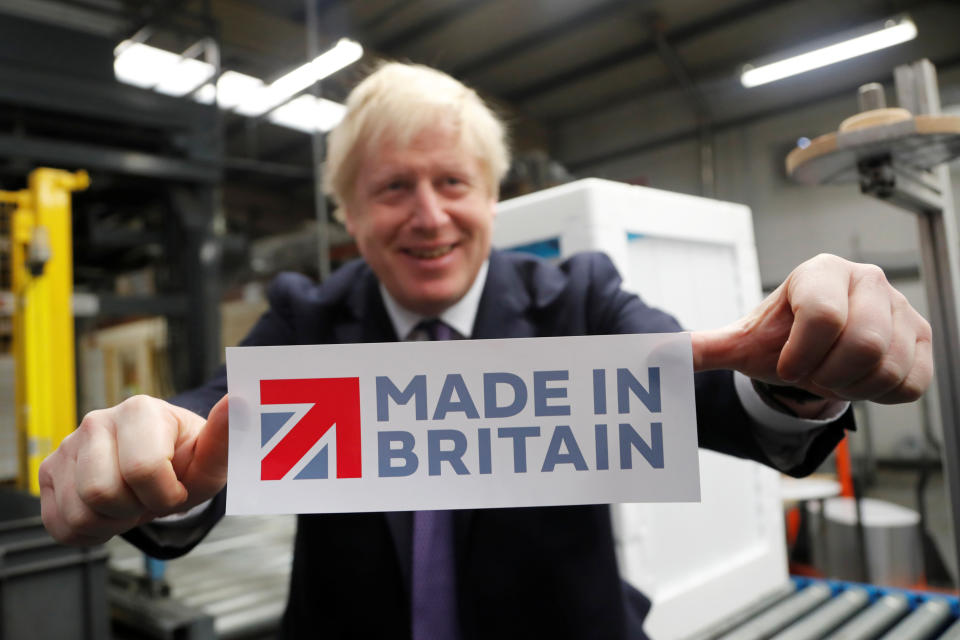 Britain's Prime Minister Boris Johnson holds a sign he took off the packaging of a washing machine at Ebac electrical appliances manufacturer during a General Election campaign trail stop in Newton Aycliffe, Britain November 20, 2019. Frank Augstein/Pool via REUTERS