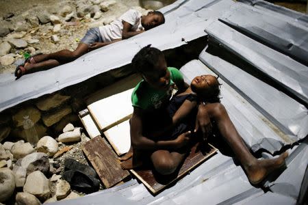 Children sleep over metal sheets in a partially destroyed school used as a shelter after Hurricane Matthew hit Jeremie, Haiti. REUTERS/Carlos Garcia Rawlins