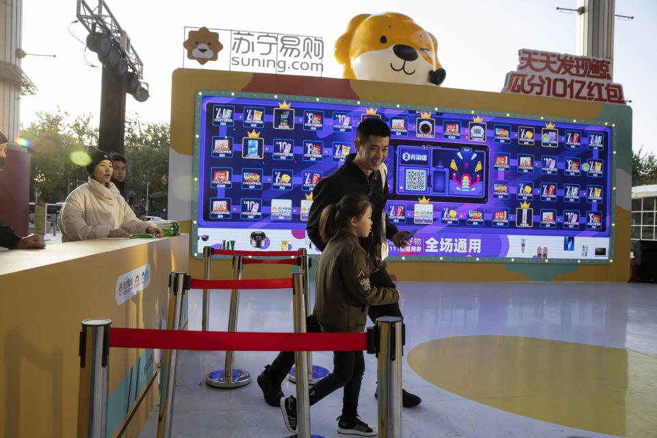 In this photo taken Sunday, Nov. 10, 2019, shoppers react after taking part in a promotion ahead of Nov. 11 Singles day in Beijing. Chinese online shoppers hunt bargains on Singles Day, a holiday invented in the 1990s that has become the world's busiest day for online commerce. (AP Photo/Ng Han Guan)