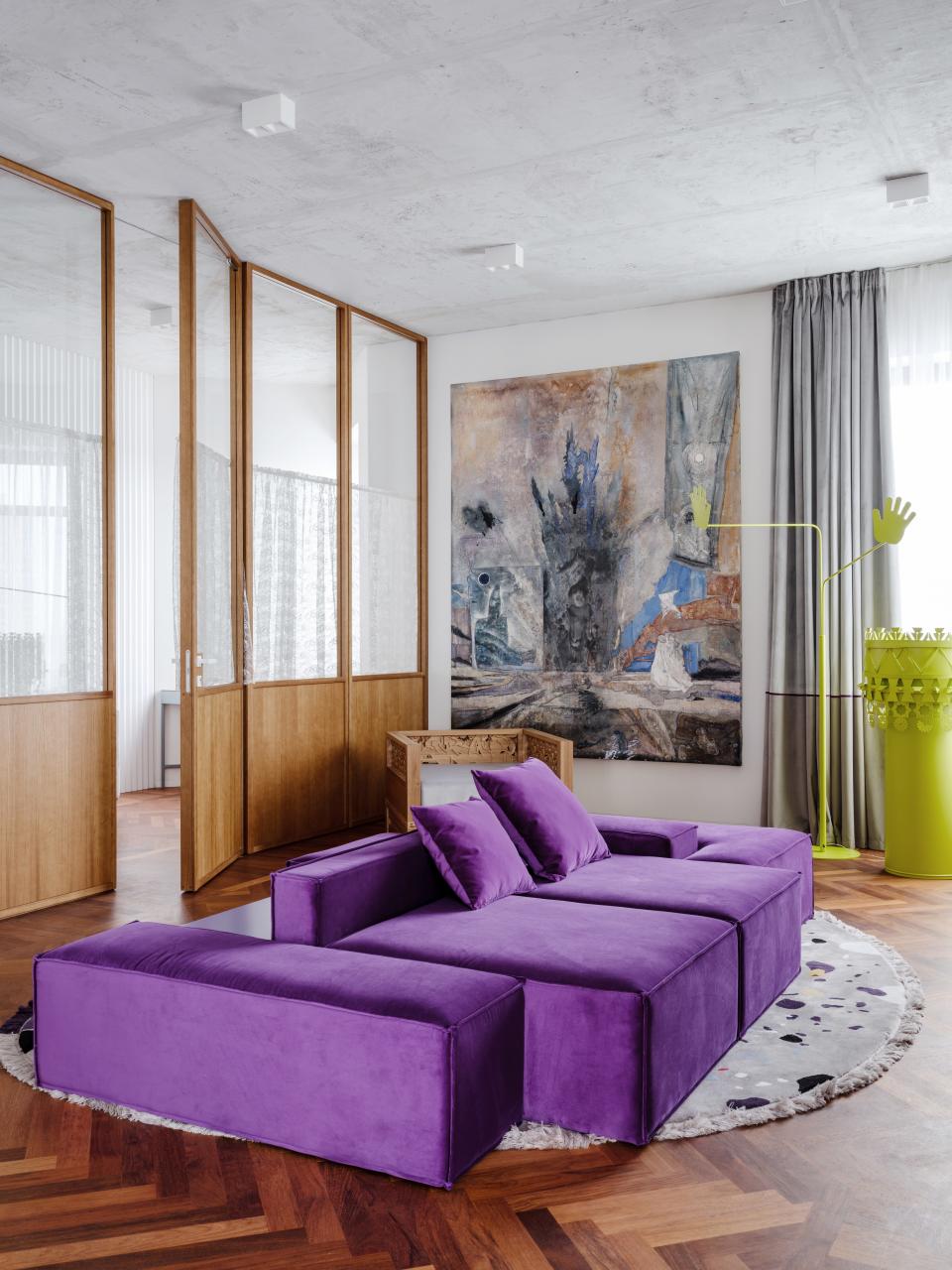 For fashion designer Ksenia Chilingarova's Moscow apartment, Crosby Studios' Harry Nuriev took inspiration from Soviet office design. In the living room, parquet floors and wood-paneled walls are paired with a custom purple sofa, carved-oak chair, lamp by Nuriev for Opening Ceremony, and painting by Nikolay Koshelev.