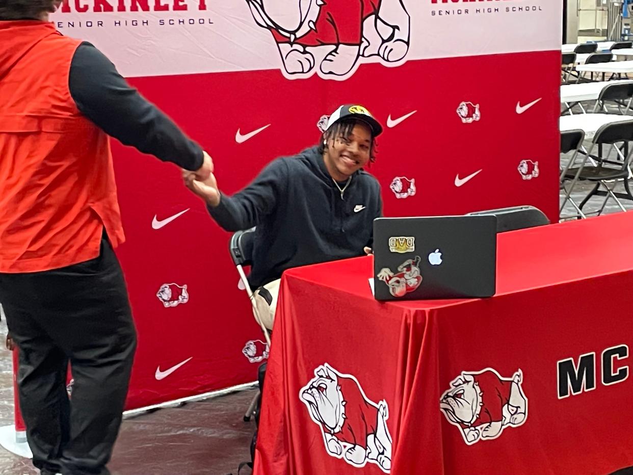 Canton McKinley football star Dante McClellan is congratulated by assistant coach Edwin Glick after McClellan announced his verbal commitment to the University of Missouri on Monday, April 22 at Memorial Field House.