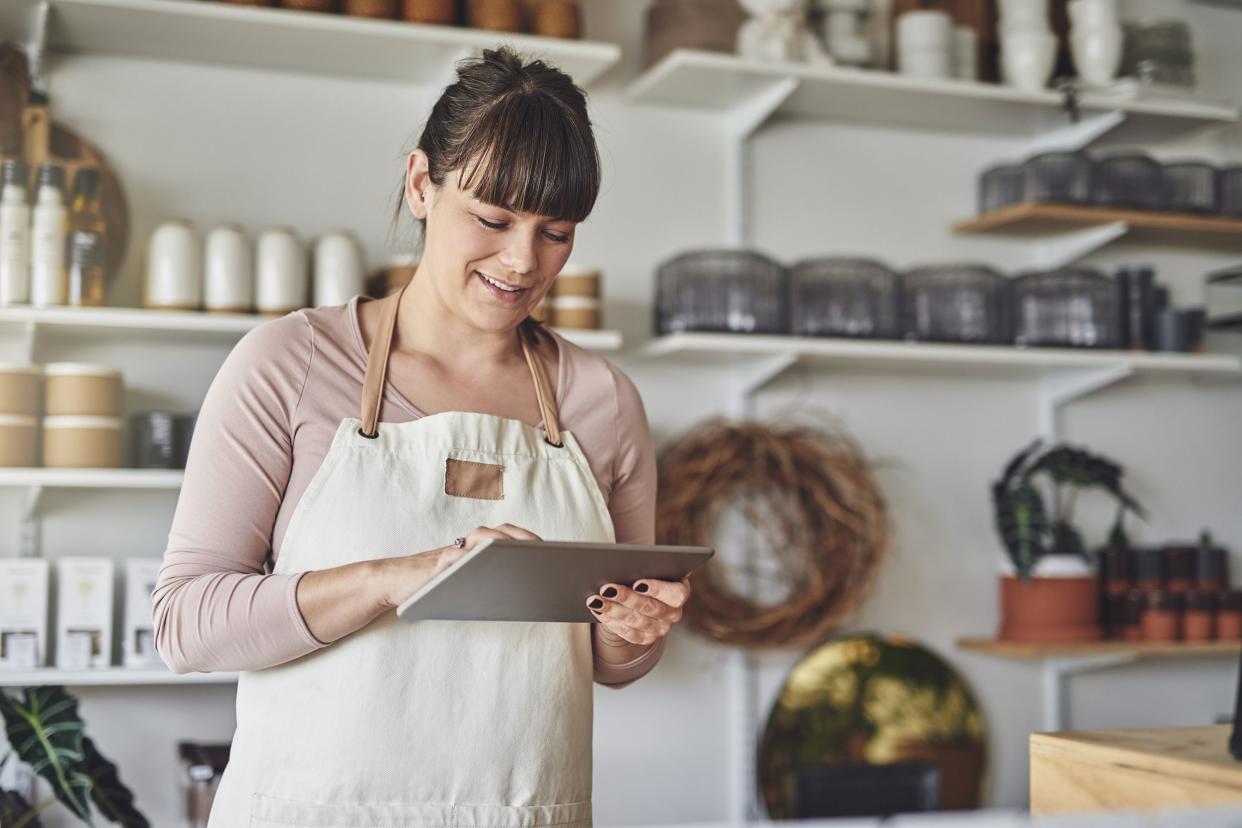 young female florist using a digital tablet in her flower shop