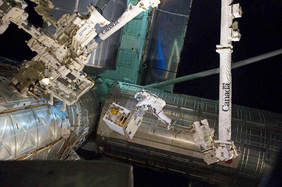 As it stands, there are plenty of satellites orbiting the planet that weren't designed to be serviced and refueled. The Robotic Refueling Mission aims to make the ISS into a service station that can handle those tasks, with the help of a two-armed robotic handyman named Dextre. Here astronauts unload the mission module and place it on a temporary platform near the robot.