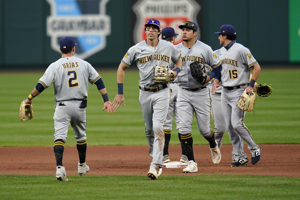 Members of the Milwaukee Brewers including Luis Urias (2) and Christian Yelich, second from left, celebrate a 3-0 victory over the St. Louis Cardinals in the first game of a baseball doubleheader Friday, Sept. 25, 2020, in St. Louis. (AP Photo/Jeff Roberson)