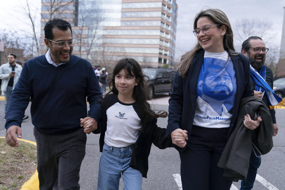 El excandidato presidencial nicaragüense Felix Maradiaga se reúne con su esposa, Berta Valle, y su hija, Alejandra, y caminan juntos después de la llegada de Maradiaga desde Nicaragua al aeropuerto internacional de Washington Dulles, en Chantilly, Virginia, el jueves 9 de febrero de 2023. (AP Foto/Jose Luis Magana)