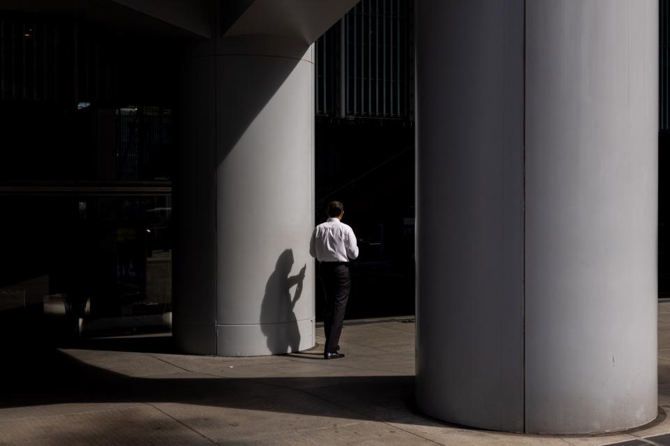 An office worker in the Central district in Hong Kong, China, on Monday, Nov. 20, 2023. Photographer: Paul Yeung/Bloomberg